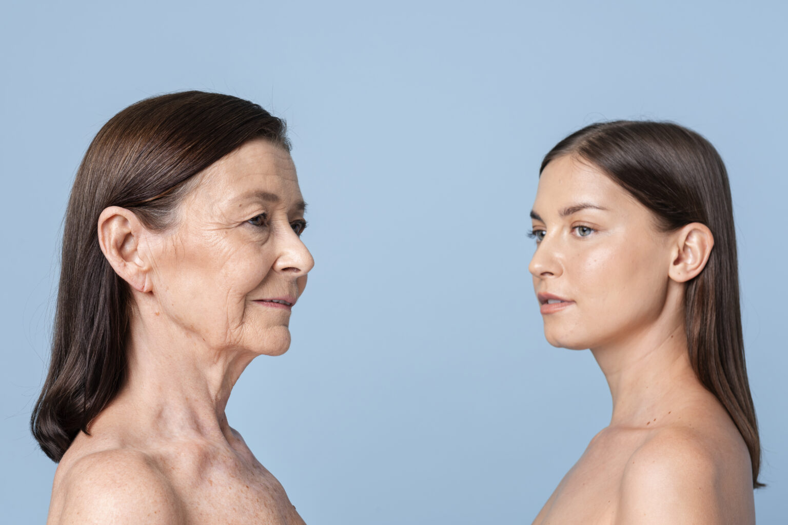 Two women standing against a blue background